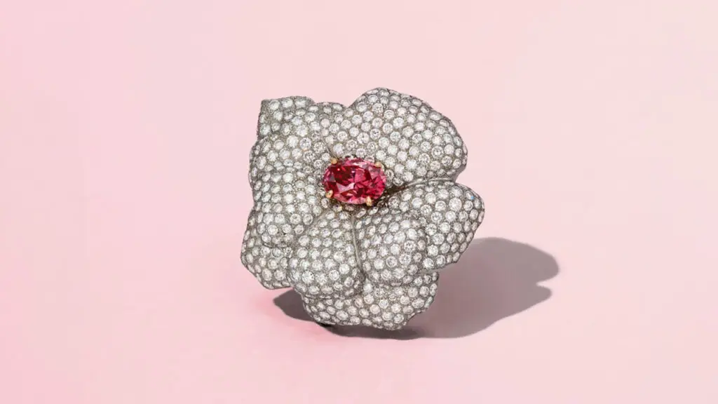 A brooch designed as a flower centering an oval brilliant-cut, 1.78-carat, fancy-purplish-red, SI2, type Ia diamond in a round-diamond surround at Christie's image