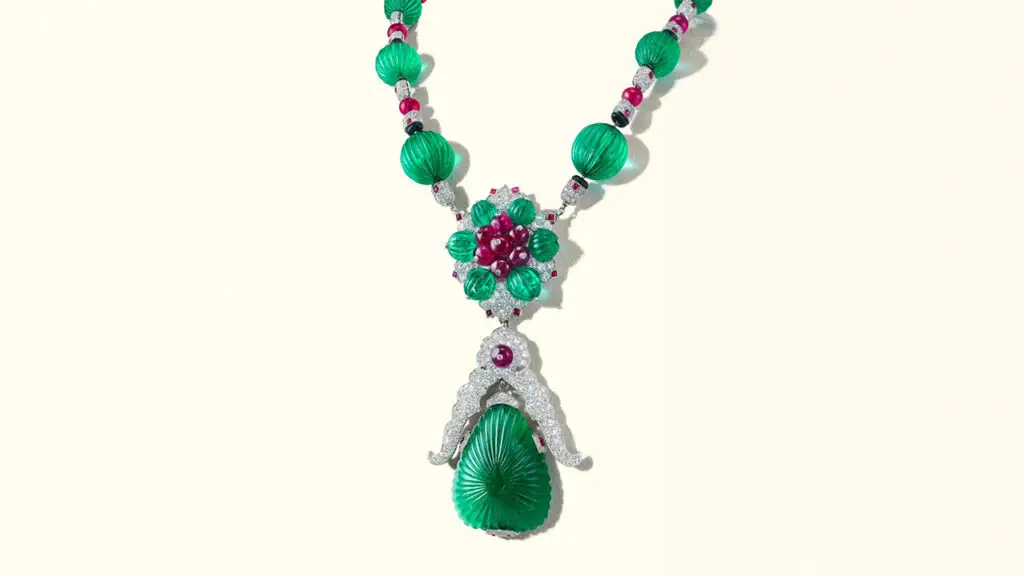 A Van Cleef & Arpels pendant necklace that detaches into brooches. The piece contains carved emeralds, ruby beads and buff top rubies, round and single-cut diamonds, and onyx beads at Christie's image