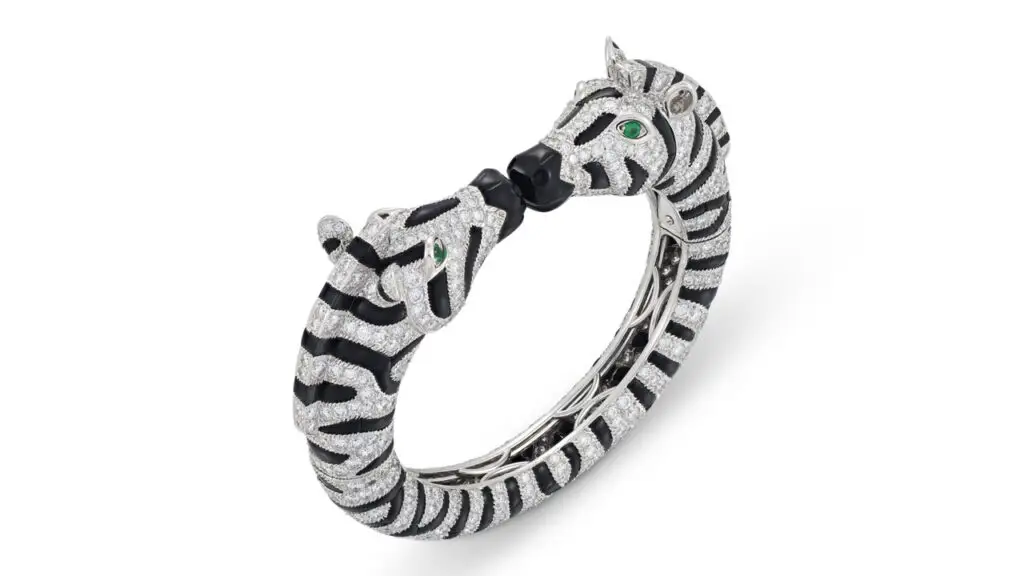 A Cartier bangle from the 1990s features two zebra heads comprising circular-cut diamonds, buff-top onyx cabochons and circular-cut emerald as eye at Christie's image