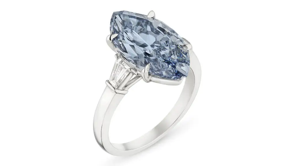 A ring bearing a marquise modified brilliant-cut, 5.04-carat, fancy-vivid-blue, VVS2, potentially internally flawless, type IIb diamond between two baguette-cut diamonds at Christie's image