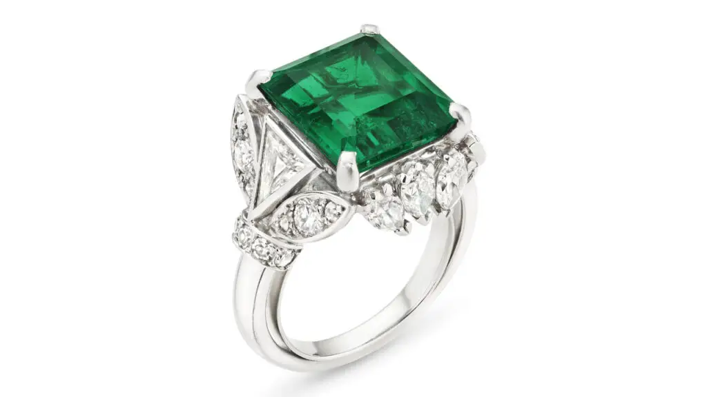 This Cartier ring bears a rectangular modified emerald-cut, 5.99-carat Colombian emerald in a surround of triangular, marquise, round, old and single-cut diamonds at Christie's image