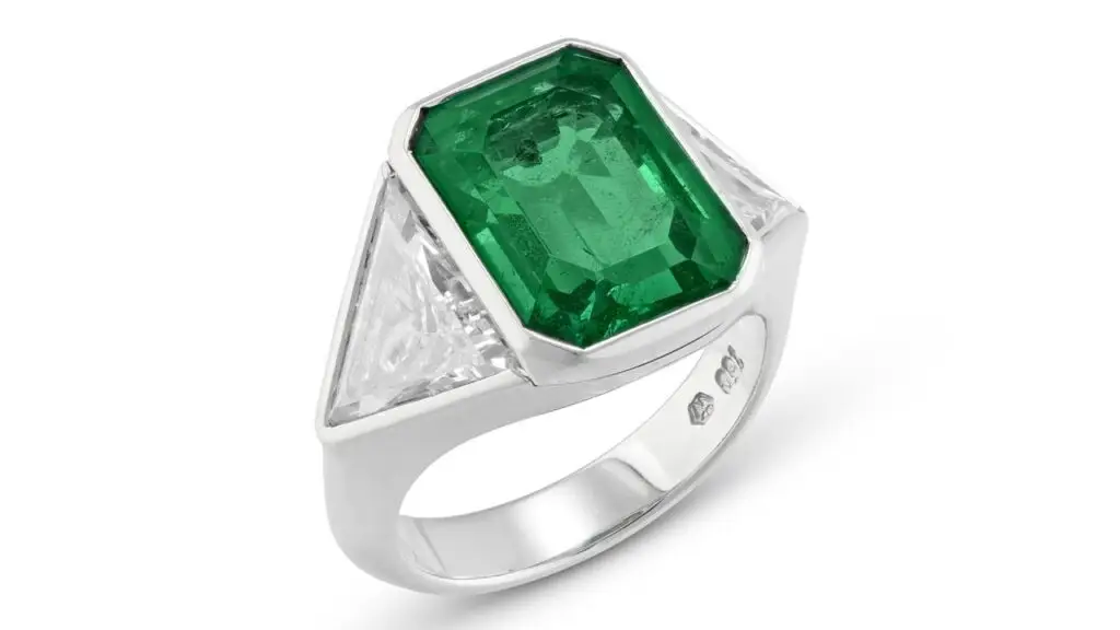 A ring centering an octagonal-shaped, 6.76-carat Colombian emerald between triangular-shaped diamonds at Christie's image