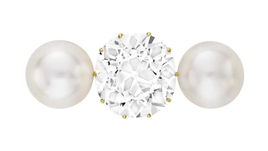 A brooch designed circa 1900, featuring an old mine brilliant-cut, 18.27-carat, D, SI1 diamond between two button-shaped natural pearls at Christie's image