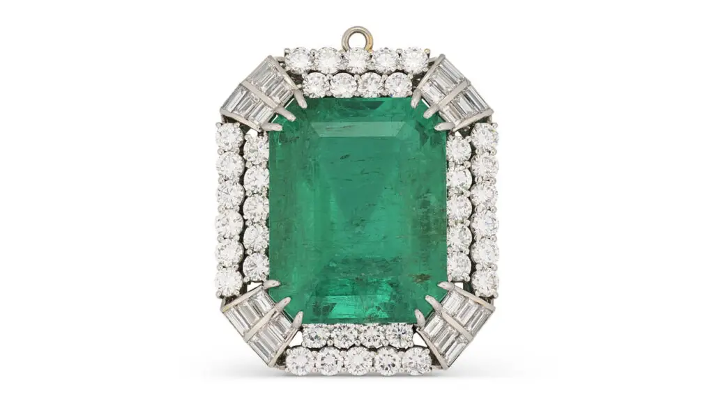 A pendant centering a rectangular Colombian emerald in a circular- and baguette-cut diamond surround at Christie's image