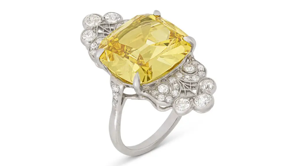 Made in the early 20th century, this ring centers a cushion brilliant-cut, 8.56-carat, fancy-vivid-orange-yellow, VS2-clarity diamond with old- and single-cut and round diamonds at Christie's image