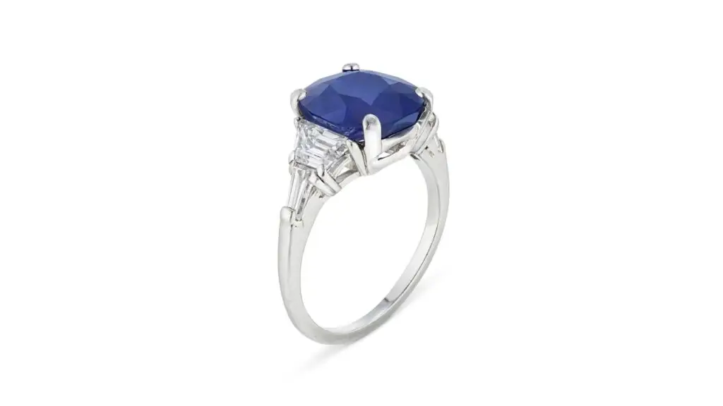 A ring centering a cushion mixed-cut, 4.81-carat Kashmir sapphire between trapezoid-shaped diamonds at Christie's image