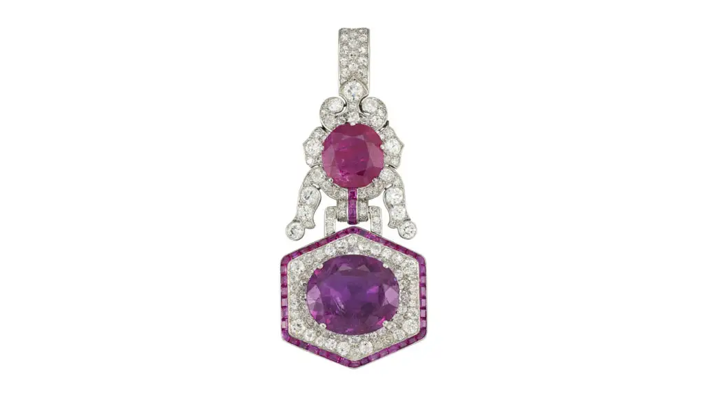 An antique cushion-shaped, 8.92-carat Burmese ruby and an antique cushion-shaped, 21.02-carat Burmese pink sapphire are ensconced within a frame of rubies and diamonds in this pendant at Christie's image