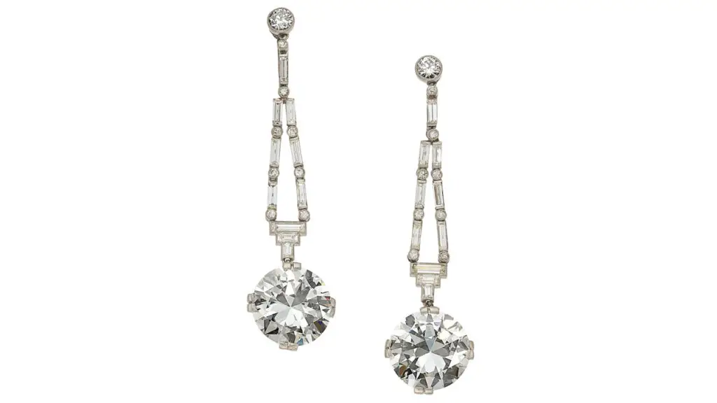 A pair of Art Deco diamond earrings sporting round brilliant-cut diamonds. One is a 5.16-carat, H, VS1 stone and the other a 5.08-carat, H, VS2 diamond, hanging from round brilliant, baguette and full-cut diamonds at Heritage Auctions image