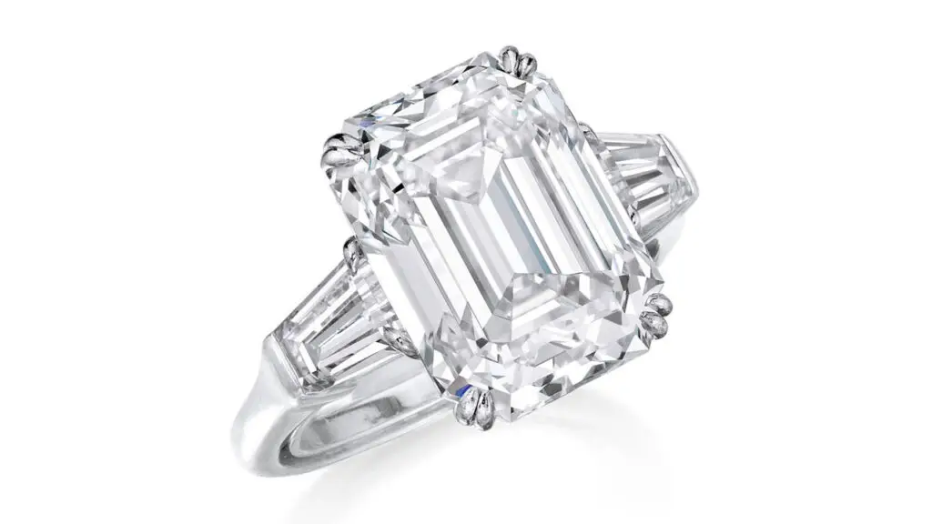 A ring centering a step-cut, 7.30-carat, F-color, VS1 diamond flanked by two tapered baguette diamonds at Phillips image
