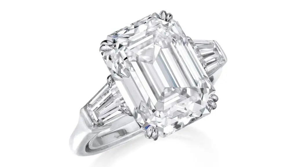 A step-cut, 7.30-carat, F, VS1 diamond — flanked by tapered baguette diamonds — is the star of this ring at Phillips image