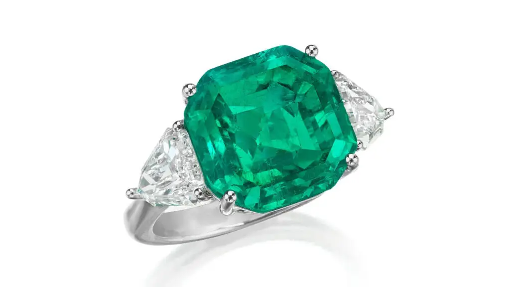 A ring with an octagonal step-cut, 8.08-carat Colombian emerald between two calf’s head-cut diamonds at Phillips image