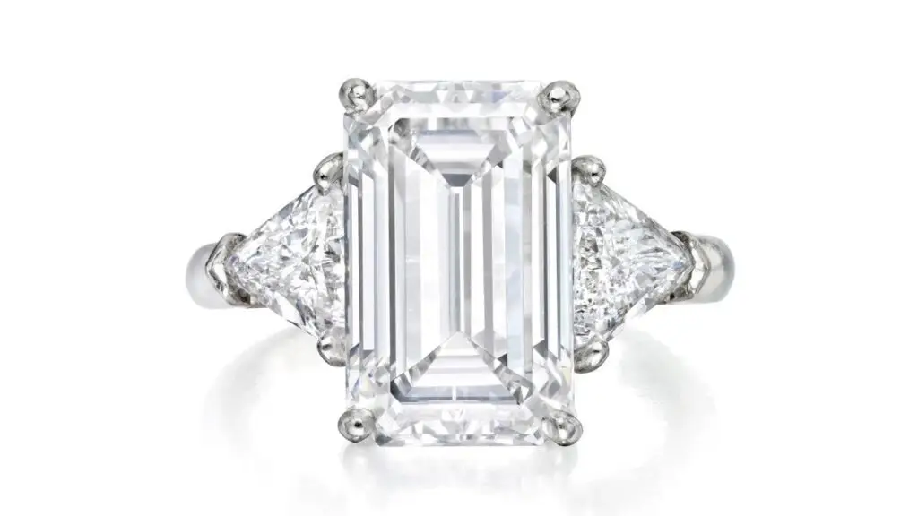 A ring centering a step-cut, 5.29-carat, D, VS1 diamond between two triangular stones at Phillips image