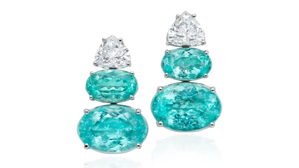 A pair of earrings, each comprising two oval Mozambique Paraiba tourmalines, weighing a total of approximately 14 carats. They are suspended from reverse-set heart-shaped diamonds, one a 1.02-carat, F, VS1 diamond and the other a 1.07-carat, F, VS1 stone at Phillips image