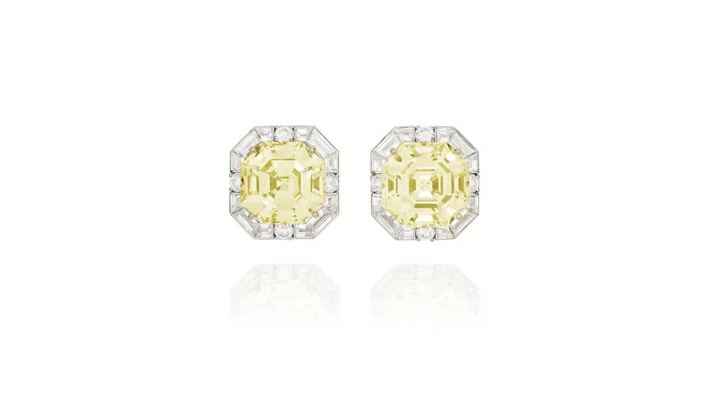 A pair of Graff earrings with octagonal step-cut, fancy-yellow diamond center stones weighing 21.38 and 20.33 carats surrounded by diamonds at Phillips image