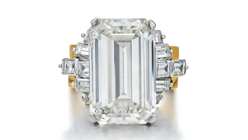 This ring features an emerald-cut, 13.01-carat, J-color, VS2 diamond with baguette-diamond accents and a removable gold jacket at Sotheby's image
