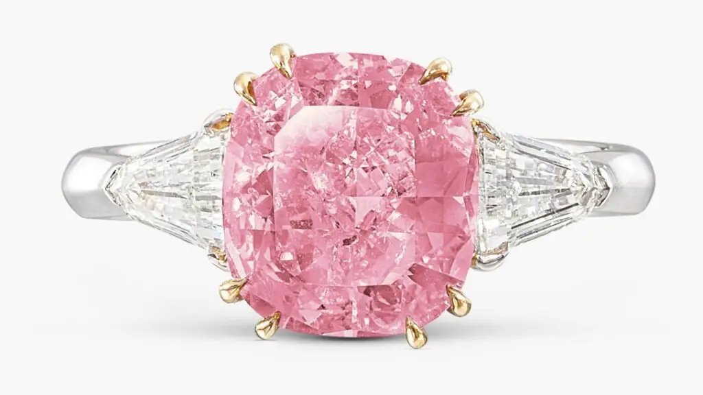 A ring with a cushion-shaped, 2.86-carat, fancy-vivid-purplish-pink, I2-clarity diamond flanked by two shield-shaped diamonds at Sotheby's image