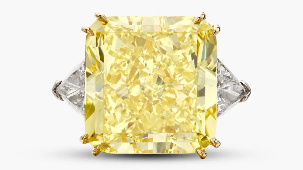 A ring with a round cornered square modified brilliant-cut, 34.75-carat, fancy-intense-yellow, VS1 diamond between by two triangle-shaped diamonds at Sotheby's image