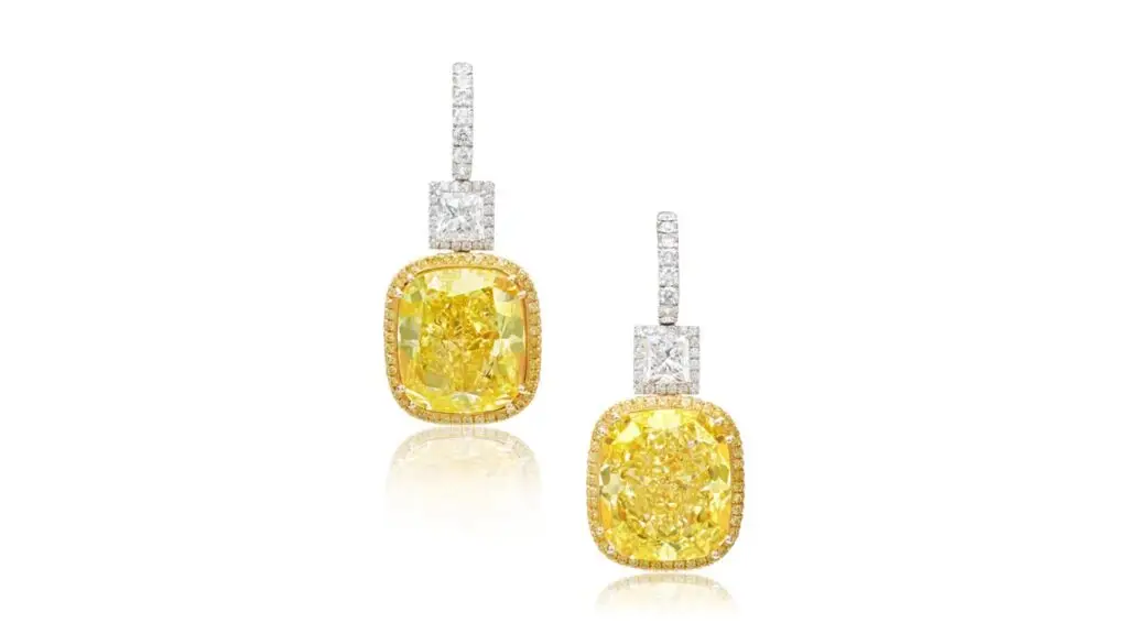 These earrings from Schreiner feature cushion modified brilliant-cut, fancy-vivid yellow diamonds weighing 38.66 and 38.88 carats, suspended from rectangular modified brilliant-cut diamonds weighing 2 and 2.03 carats at Sotheby's image