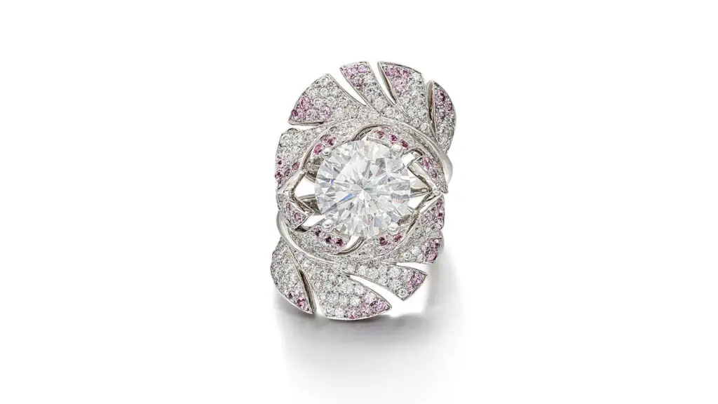 A Chanel ring is designed as two curved feathers decorated with brilliant-cut diamonds and circular-cut pink sapphires, centering a brilliant-cut, 5.51-carat, E-color diamond image