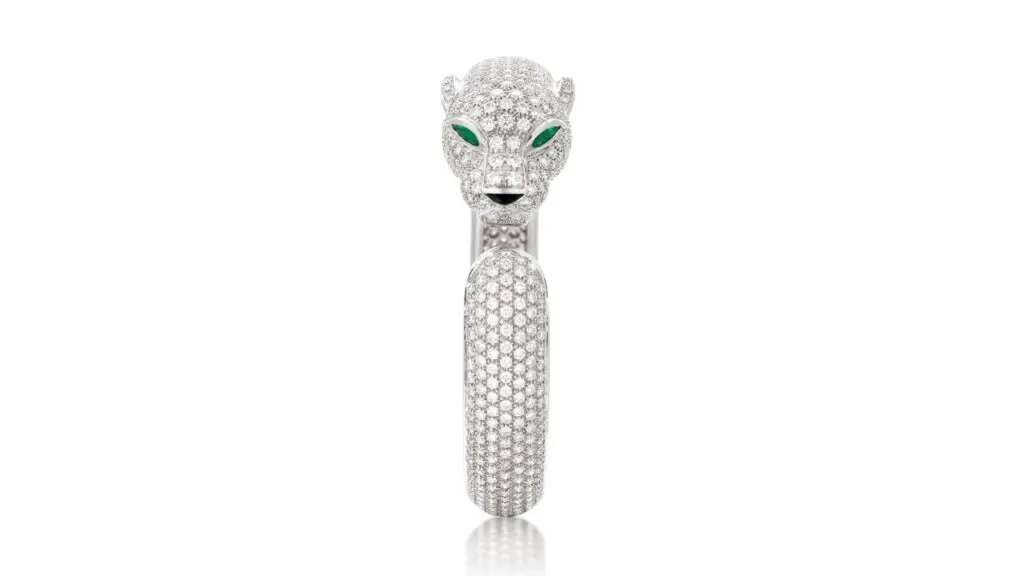 A Cartier panther bangle contains a total of 11 to 13 carats of diamonds of F to G color and VVS to VS clarity. It has pear-shaped, slightly bluish-green emeralds for eyes and an onyx nose at Sotheby's image