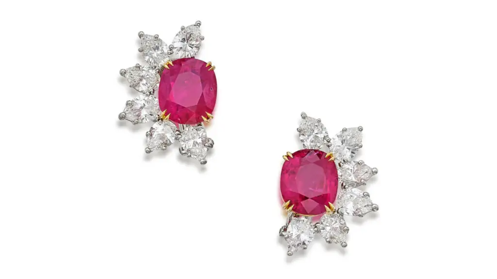 A pair of ear clips features cushion-cut, 5.12- and 5.18-carat Burmese rubies with pear-shaped diamond borders at Sotheby's image