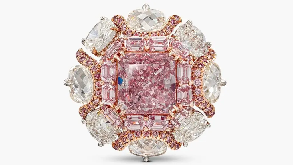 A ring, bearing a cut-cornered square modified brilliant-cut, 4.63-carat, fancy-intense-purplish-pink, I1 diamond within a surround of step-cut diamonds of pink tint at Sotheby's image