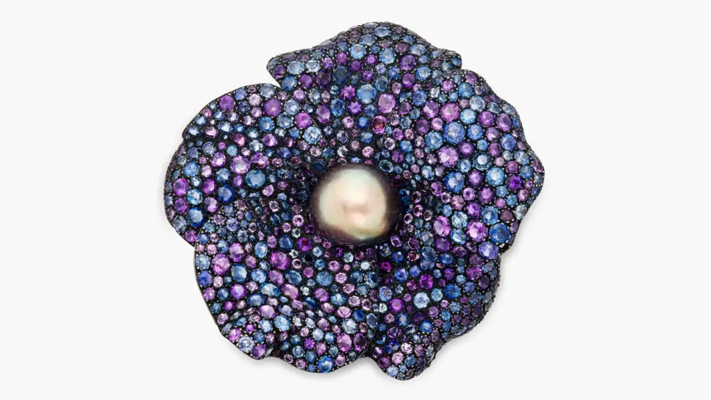 This wild rose brooch by JAR centers a button-shaped, grey natural pearl amid amethyst and sapphire petals at Sotheby's image