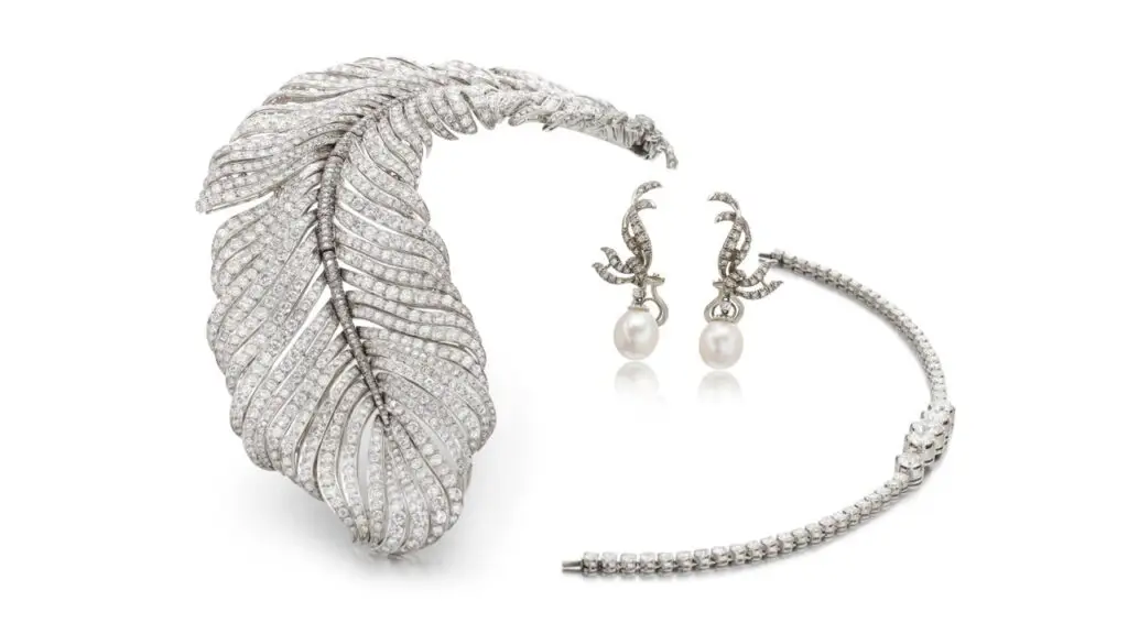 This set from 1956 comprises a piece designed as a feather with brilliant- and single-cut diamonds. It can be worn interchangeably as a necklace, brooch or hair piece. The group also includes a pair of cultured pearl and diamond ear clips at Sotheby's image