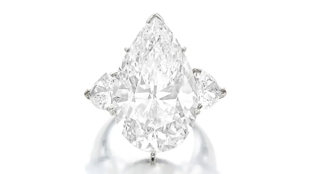 From the collection of philanthropist Geri Brawerman, this ring has a pear-shaped, 19.74-carat, H, SI1 diamond and pear-shaped diamond side stones at Sotheby's image