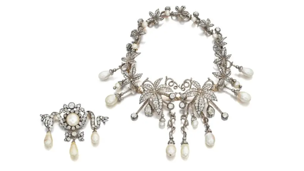 Comprising a transformable jewel designed as a graduated garland of vines, this piece contains old mine-cut diamonds set throughout, as well as rose-cut diamond accents, and suspends drop-shaped and slightly baroque-shaped natural pearls. It can create two brooches, six hairpins and two tiaras. The jewel is part of a set with a brooch designed as a ribbon and featuring old mine-cut diamonds and a pearl. Coming from a European noble family, the pearls were initially the property of Prince Franz Xaver of Saxony and Poland, whose daughter was a cousin of King Louis VXI of France at Sotheby's image