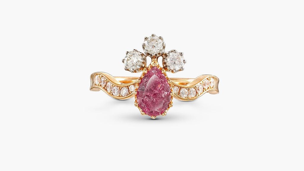 A ring centering a pear-shaped 0.88-carat, fancy-vivid-purplish-pink, I2-clarity diamond, embellished with diamonds at Sotheby's image