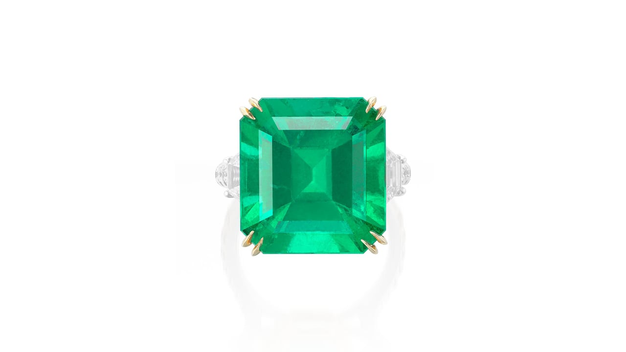 A step-cut, 15.50-carat Colombian emerald is the star of this ring. It is set between two trapeze-cut diamonds at Phillips image