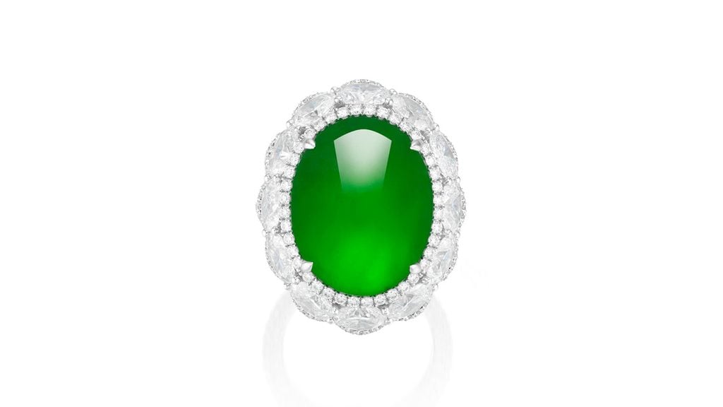 A ring centering an oval, vivid-emerald-green Burmese jadeite of high translucency, in a surround of oval and brilliant-cut diamonds and brilliant-cut diamond shoulders at Phillips image