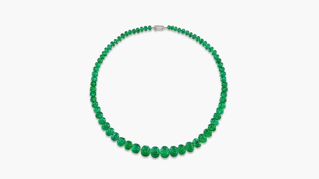 A Van Cleef & Arpels necklace featuring 72 carved Colombian emeralds beads weighing between 1.11 and 23.53 carats, with two shield-shaped diamonds on the clasp at Sotheby's image