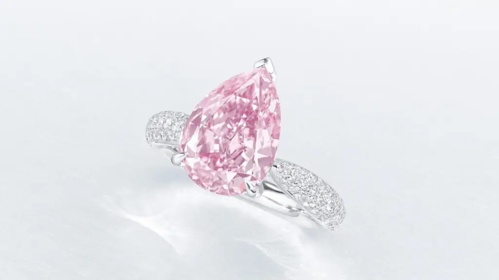 Ring featuring a pear brilliant-cut, fancy-vivid-purple-pink, internally flawless diamond with round diamonds on the band at Christie's image