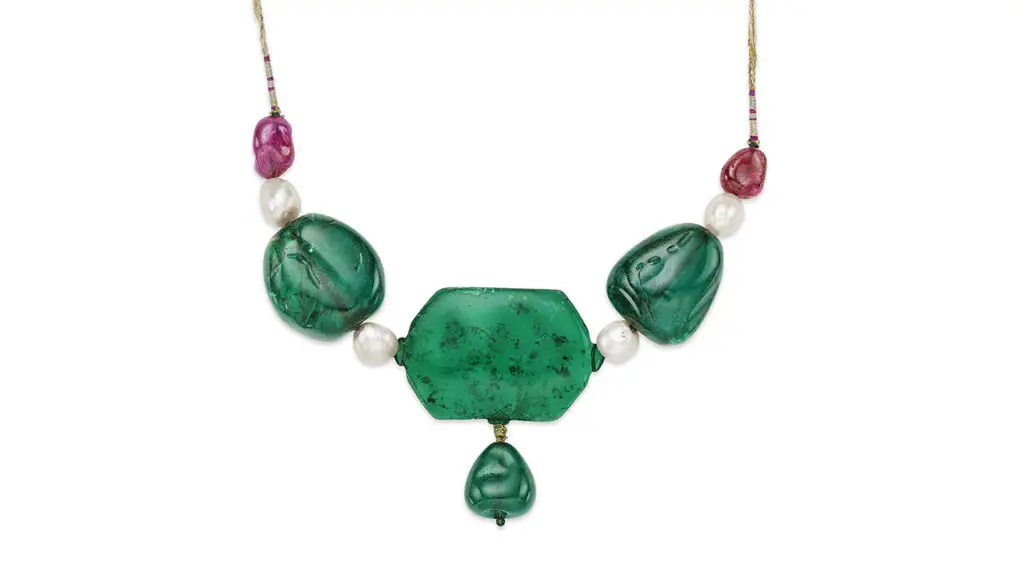 Necklace, with a hexagonal Colombian emerald center stone suspending a drop-shaped Colombian emerald, as well as two baroque-shaped emeralds, spinel, ruby and pearl, from the Mughal collection, at Christie's image