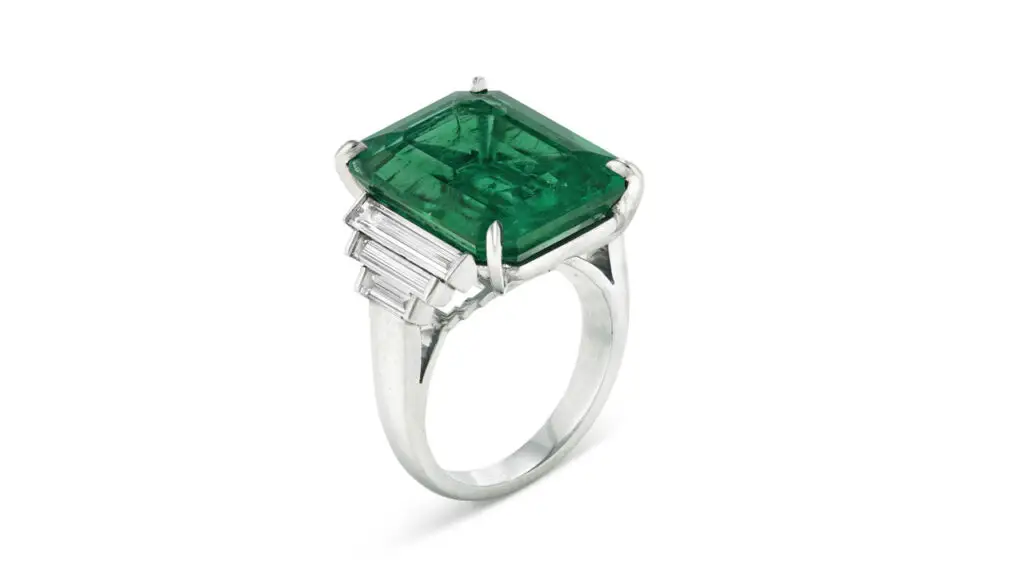 Ring bearing a rectangular emerald-cut Colombian emerald with rectangular step-cut and baguette diamonds at Christie's image