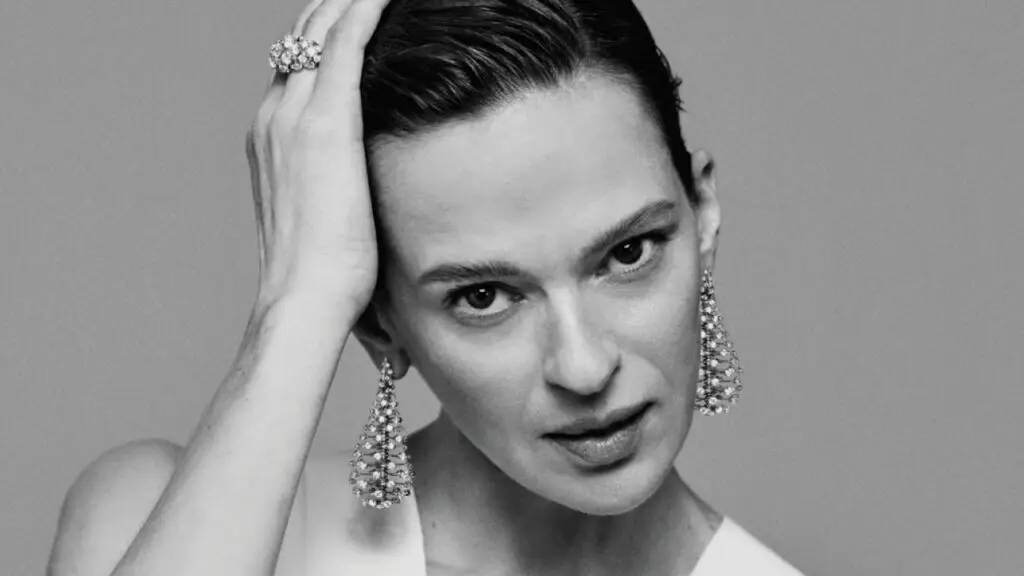 Model wearing Nikos Koulis Wish earrings and ring in 18-karat gold with diamonds image