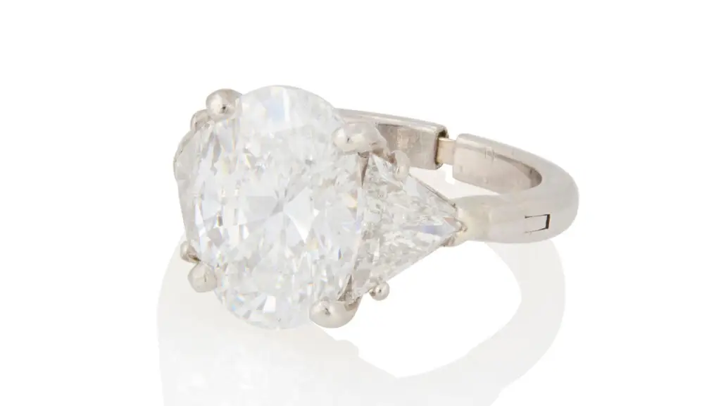 Ring centers an oval, 5.03-carat diamond between two triangular-cut diamonds at John Moran image