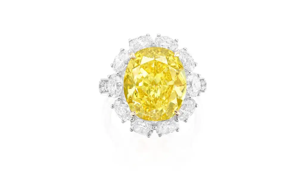 Ring bears an oval, 19.05-carat, fancy-vivid-yellow diamond in an oval-diamond surround and with brilliant-cut diamond shoulders at Phillips image