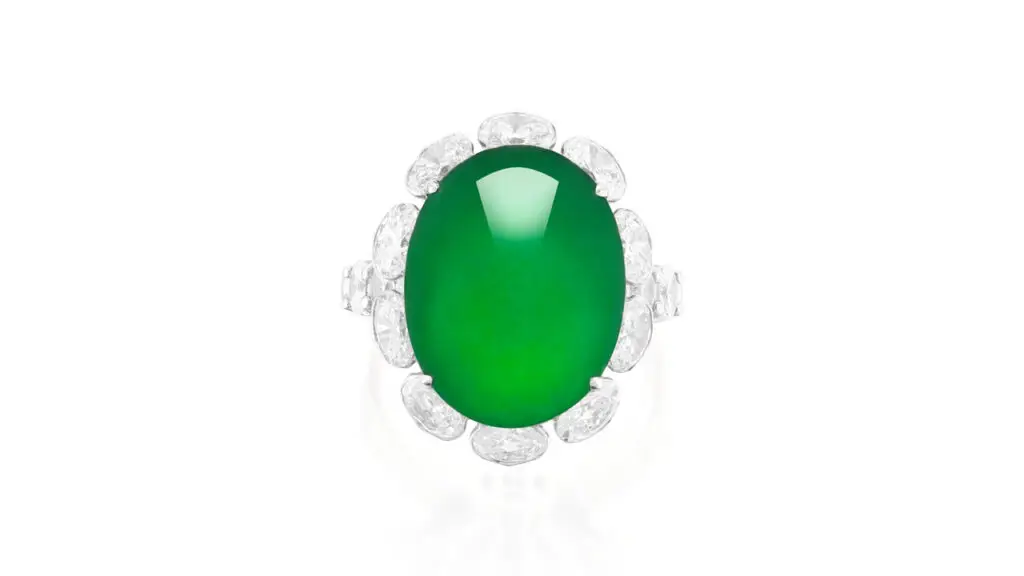 Ring sporting an oval, emerald-green jadeite cabochon with an oval-diamond surround and shoulders and a gallery decorated with brilliant-cut diamonds at Phillips image