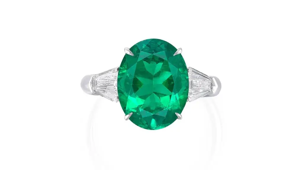 Ring, set with an oval-shaped Colombian emerald flanked by two calf’s-head shaped diamonds at Phillips image