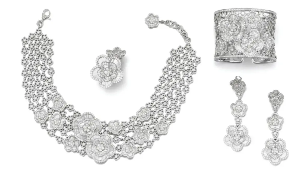 This lot by Schreiner includes a floral-design necklace with tapered-baguette and brilliant-cut diamonds, and earrings, a ring and a bangle, all with similar motifs by Sotheby's image
