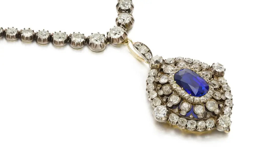 Pendant from the late 19th century bearing an oval-cut, Ceylon sapphire surrounded by cushion-shaped diamonds, with graduated cushion-shaped diamonds in pinched-collet settings along the necklace at Sotheby's image