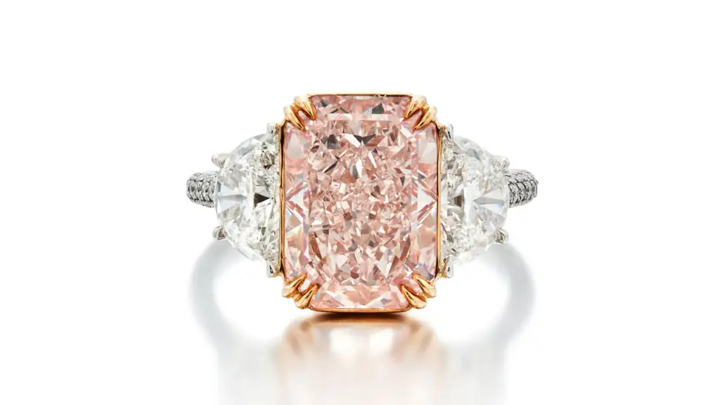 A ring with a cut-cornered, mixed-cut, fancy-pink diamond, flanked by two half-moon shaped diamonds at Sotheby's image