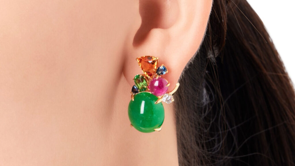 These earrings each contain an oval jadeite cabochon decorated with variously shaped garnets, rubies, sapphires and diamonds image