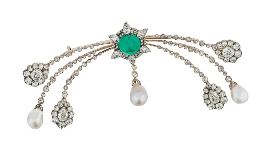 This brooch from around 1900 sports a cabochon Colombian emerald weighing approximately 13.50 carats, as well as drop-shaped natural pearls and pear-shaped, old- and rose-cut diamonds at Christie's image