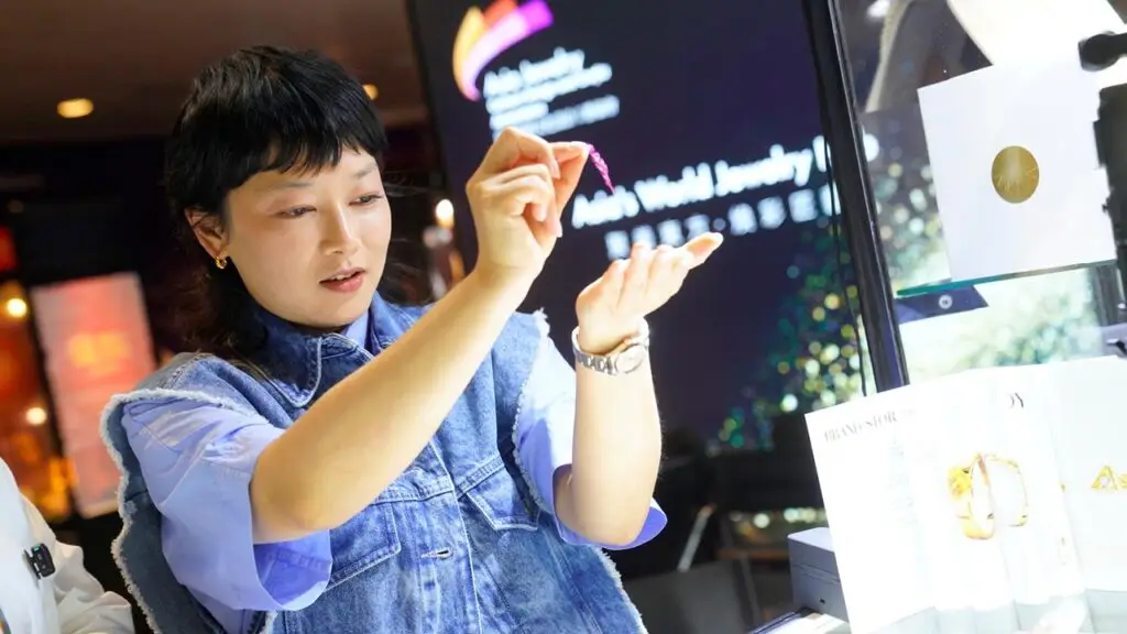 Attendee inspecting designs at the Hong Kong International Jewellery Show image