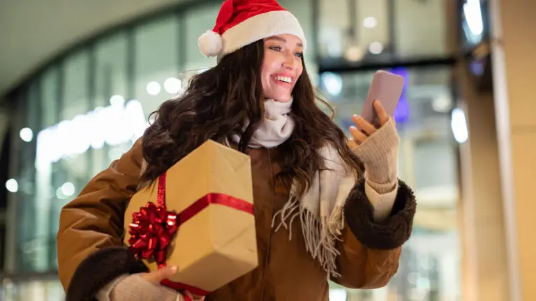 A woman carrying a holiday gift image