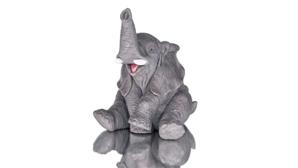 An 11.8-centimeter carving of an elephant in dark gray obsidian, with a rhodonite tongue, cacholong tusks, and black onyx eyes image